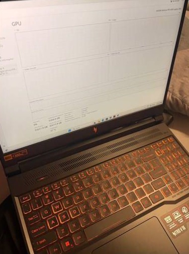 A buyer’s photo of their Acer Nitro V 16 switched on at home, its keyboard lit red